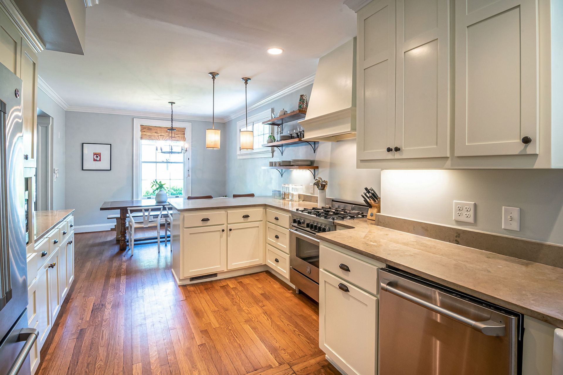 Bright and spacious kitchen interior with modern appliances, wooden flooring, and ample natural light.